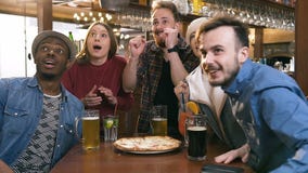 Vijf hipstervrienden die bier, cocktail drinken terwijl het toejuichen van voor sporten spel in bar, bar, stock footage Vijf hipstervrienden die bier, cocktail drinken terwijl het toejuichen van voor sporten spel in bar, bar, stock footage