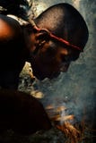 Village de Walarano, île de Malekula/Vanuatu - 9 JUILLET 2016 : homme tribal local soufflant à un feu pour l'allumer sur le tradi photos stock Village de Walarano, île de Malekula/Vanuatu - 9 JUILLET 2016 : homme tribal local soufflant à un feu pour l'allumer sur le tradi photos stock