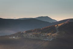 Village en montagnes de VOSGES à la lumière du soleil de début de la matinée avec le brouillard se levant des alpes de forêt à l' photo stock Village en montagnes de VOSGES à la lumière du soleil de début de la matinée avec le brouillard se levant des alpes de forêt à l' photo stock