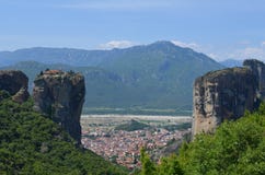 Villaggio di Kalambaka fra i monasteri sulla cima di roccia, un giorno di estate in Meteora, la Grecia immagine stock libera da diritti Villaggio di Kalambaka fra i monasteri sulla cima di roccia, un giorno di estate in Meteora, la Grecia immagine stock libera da diritti