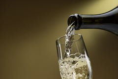 Vin blanc pleuvant à torrents dans un verre à vin image libre de droits Vin blanc pleuvant à torrents dans un verre à vin image libre de droits