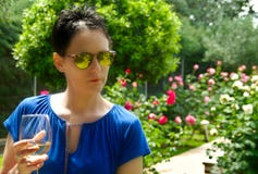 Vin blanc potable de jeune femme dans le jardin photo libre de droits Vin blanc potable de jeune femme dans le jardin photo libre de droits