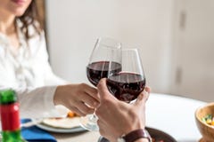 Vin de consommation et potable de jeunes couples heureux à la maison et grillant avec du vin images libres de droits Vin de consommation et potable de jeunes couples heureux à la maison et grillant avec du vin images libres de droits
