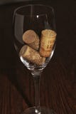Vinexponeringsglas med tre korkar inom på en trätabell royaltyfria foton Vinexponeringsglas med tre korkar inom på en trätabell royaltyfria foton