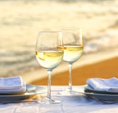 Vino blanco en la playa por una tarde romántica foto de archivo Vino blanco en la playa por una tarde romántica foto de archivo