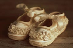 Vintage baby shoes on wood background stock photos Vintage baby shoes on wood background stock photos