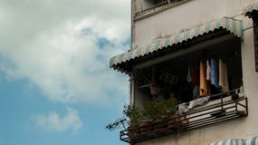 Vintage Blue Balcony Window with Colorful Clothes and Plant Pots royalty free stock photos Vintage Blue Balcony Window with Colorful Clothes and Plant Pots royalty free stock photos