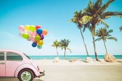 Vintage car with colorful balloon on tropical beach