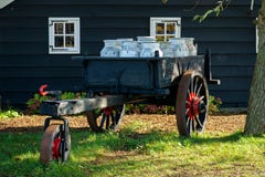 Vintage cart with dairy milk cans in front of traditional old wooden house royalty free stock photos Vintage cart with dairy milk cans in front of traditional old wooden house royalty free stock photos