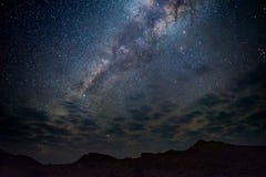 Vintergatanbåge, stjärnor i himlen, den Namib öknen i Namibia, Afrika Några sceniska moln royaltyfri fotografi Vintergatanbåge, stjärnor i himlen, den Namib öknen i Namibia, Afrika Några sceniska moln royaltyfri fotografi