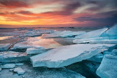 Vinterlandskap på kusten under solnedgång Lofoten öar, Norge Is och solnedgånghimmel royaltyfri bild Vinterlandskap på kusten under solnedgång Lofoten öar, Norge Is och solnedgånghimmel royaltyfri bild