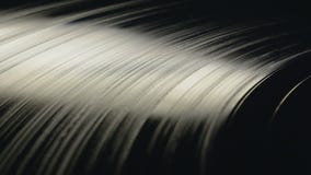 Vinyl Record playing on turntable. Modern vinyl record plate rotating in beautiful soft light, view from top, close up Vinyl Record playing on turntable. Modern vinyl record plate rotating in beautiful soft light, view from top, close up