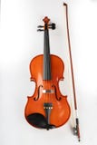 Violino e curva em um fundo claro Um instrumento musical amarrado novo fotografia de stock Violino e curva em um fundo claro Um instrumento musical amarrado novo fotografia de stock