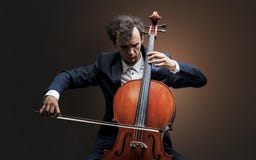 Violoncellista che gioca sullo strumento con l'empatia fotografie stock libere da diritti Violoncellista che gioca sullo strumento con l'empatia fotografie stock libere da diritti