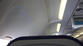 Visage heureux d'enfant apparaissant derrière la chaise dans l'avion, cache-cache de jeu banque de vidéos Visage heureux d'enfant apparaissant derrière la chaise dans l'avion, cache-cache de jeu banque de vidéos