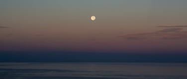Visión espectacular desde una gran luna sobre el mar fotografía de archivo Visión espectacular desde una gran luna sobre el mar fotografía de archivo