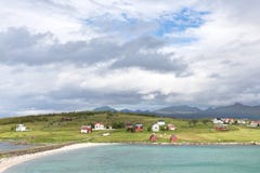 Visión sobre un fiordo noruego a una isla con las chozas de la pesca y r imagenes de archivo Visión sobre un fiordo noruego a una isla con las chozas de la pesca y r imagenes de archivo