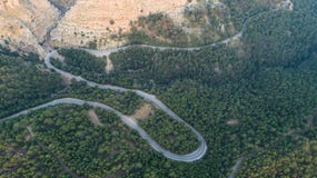 Vista aerea della strada della curva della montagna Foresta verde al tramonto di estate in Europa Abbellisca con la strada asfalt fotografie stock Vista aerea della strada della curva della montagna Foresta verde al tramonto di estate in Europa Abbellisca con la strada asfalt fotografie stock