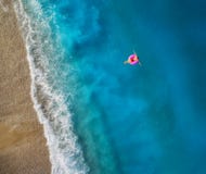 Vista aerea di nuoto della giovane donna sull'anello rosa di nuotata fotografia stock libera da diritti Vista aerea di nuoto della giovane donna sull'anello rosa di nuotata fotografia stock libera da diritti