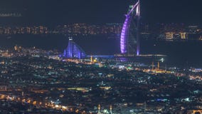 Vista aérea del horizonte de la ciudad de Dubai en la noche con el timelapse árabe iluminado del hotel del al del burj almacen de metraje de vídeo Vista aérea del horizonte de la ciudad de Dubai en la noche con el timelapse árabe iluminado del hotel del al del burj almacen de metraje de vídeo