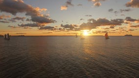 Vista aérea dos iate com as velas no mar com opiniões cênicos bonitas de um por do sol Os iate competem no mar aberto video estoque Vista aérea dos iate com as velas no mar com opiniões cênicos bonitas de um por do sol Os iate competem no mar aberto video estoque