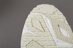 Vista dal basso di una sogliola beige delle scarpe da tennis fotografia stock libera da diritti Vista dal basso di una sogliola beige delle scarpe da tennis fotografia stock libera da diritti