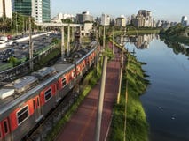 Vista das construções, do trem de CPTM, do tráfego dos veículos e do rio na avenida marginal do rio de Pinheiros imagem de stock Vista das construções, do trem de CPTM, do tráfego dos veículos e do rio na avenida marginal do rio de Pinheiros imagem de stock
