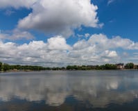 Vista de la charca y de las nubes superiores reflejadas en ella, Kaliningrado, Rusia fotografía de archivo Vista de la charca y de las nubes superiores reflejadas en ella, Kaliningrado, Rusia fotografía de archivo