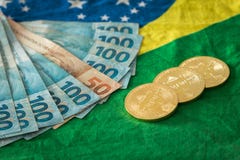 Vista del dinero y de los bitcoins brasileños contra la bandera brasileña fotografía de archivo Vista del dinero y de los bitcoins brasileños contra la bandera brasileña fotografía de archivo