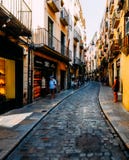 Vista grandangolare della via stretta del ciottolo nel centro storico di Girona fotografia stock libera da diritti Vista grandangolare della via stretta del ciottolo nel centro storico di Girona fotografia stock libera da diritti