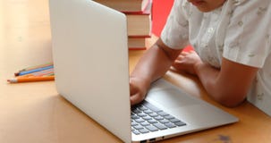 Vista lateral del colegial asiático atento que estudia con el ordenador portátil en una sala de clase en la escuela 4k metrajes Vista lateral del colegial asiático atento que estudia con el ordenador portátil en una sala de clase en la escuela 4k metrajes