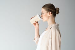 vista laterale del caffè bevente della bella giovane donna da andare fotografie stock vista laterale del caffè bevente della bella giovane donna da andare fotografie stock