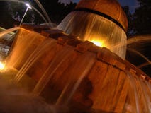 Vista nocturna de la agua corriente del parque de Herzel de la fuente local de la rana, iluminada por las luces ámbar calientes imagen de archivo libre de regalías Vista nocturna de la agua corriente del parque de Herzel de la fuente local de la rana, iluminada por las luces ámbar calientes imagen de archivo libre de regalías