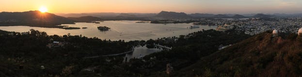 Vista panorâmica no por do sol da cidade, dos lagos, dos palácios e do campo de Udaipur do Karni Mata Ropeway, Udaipur, Rajasthan fotografia de stock royalty free Vista panorâmica no por do sol da cidade, dos lagos, dos palácios e do campo de Udaipur do Karni Mata Ropeway, Udaipur, Rajasthan fotografia de stock royalty free
