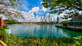 Vista scenica dei giri delle montagne russe attraverso il lago blu negli studi universali di Florida fotografia stock libera da diritti Vista scenica dei giri delle montagne russe attraverso il lago blu negli studi universali di Florida fotografia stock libera da diritti