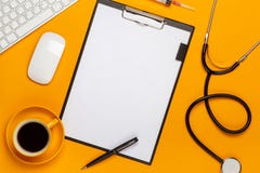 Vista superior de la tabla de un doctor con la libreta y estetoscopio de la pluma, teclado, prescripción y píldoras, una taza de fotos de archivo Vista superior de la tabla de un doctor con la libreta y estetoscopio de la pluma, teclado, prescripción y píldoras, una taza de fotos de archivo
