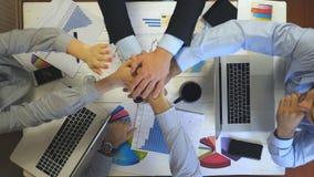 Vista superior a las manos de cuatro hombres de negocios que celebran el logro El grupo de patrones apiló los brazos juntos uno p metrajes Vista superior a las manos de cuatro hombres de negocios que celebran el logro El grupo de patrones apiló los brazos juntos uno p metrajes
