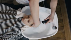 Vista superior O estilista lava o cabelo do indivíduo novo no salão de beleza ou no barbeiro Cabelo de lavagem do barbeiro do seu video estoque Vista superior O estilista lava o cabelo do indivíduo novo no salão de beleza ou no barbeiro Cabelo de lavagem do barbeiro do seu video estoque