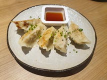 Vista superiore degli autoadesivi di vaso fritti o di Gyoza con una salsa di immersione a base di soia immagine stock libera da diritti Vista superiore degli autoadesivi di vaso fritti o di Gyoza con una salsa di immersione a base di soia immagine stock libera da diritti