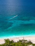 Vista superiore sulla bella spiaggia di Myrtos con acqua ed il ragazzo del turchese sull'isola di Kefalonia nel Mar Ionio in Grec fotografia stock Vista superiore sulla bella spiaggia di Myrtos con acqua ed il ragazzo del turchese sull'isola di Kefalonia nel Mar Ionio in Grec fotografia stock