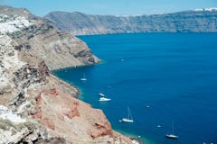 Vista tradizionale dalla riva al mare con le barche bianche sull'isola di Santorini fotografia stock Vista tradizionale dalla riva al mare con le barche bianche sull'isola di Santorini fotografia stock