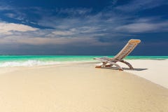 Vista tropicale della spiaggia di acqua stupefacente e della sedia vuota sulla sabbia per immagini stock libere da diritti Vista tropicale della spiaggia di acqua stupefacente e della sedia vuota sulla sabbia per immagini stock libere da diritti