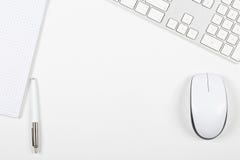 Visualizzazione da tavolino dell'ufficio bianco con il topo del computer, tastiera, notepa Fotografia Stock Visualizzazione da tavolino dell'ufficio bianco con il topo del computer, tastiera, notepa Fotografia Stock