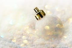 Vit julgranboll som ligger i banken av för Garland Glittering Bokeh Lights Festive för pastellfärgad färg för snö det guld- lynne Arkivfoton Vit julgranboll som ligger i banken av för Garland Glittering Bokeh Lights Festive för pastellfärgad färg för snö det guld- lynne Arkivfoton