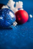 Vit, silver och röda xmas-prydnader på mörker - blått blänker bakgrund med utrymme för text arkivfoton Vit, silver och röda xmas-prydnader på mörker - blått blänker bakgrund med utrymme för text arkivfoton