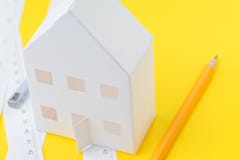 Vitbokhus, gul blyertspenna och vita mäta band med cm och tum på livlig gul bakgrund, arkitektur, arkivbilder Vitbokhus, gul blyertspenna och vita mäta band med cm och tum på livlig gul bakgrund, arkitektur, arkivbilder