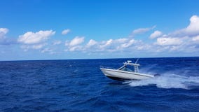 Vitesse pêchant le bateau tendre sautant les vagues en mer et croisant le jour bleu d'océan en Bahamas La belle eau bleue images stock Vitesse pêchant le bateau tendre sautant les vagues en mer et croisant le jour bleu d'océan en Bahamas La belle eau bleue images stock