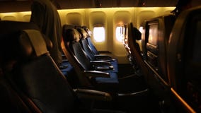 Vliegtuigcabine met passagiers die en met een zonsonderganglicht inschepen zitten stock video Vliegtuigcabine met passagiers die en met een zonsonderganglicht inschepen zitten stock video