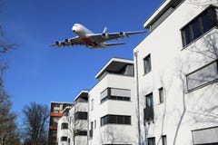 Vliegtuigenlawaai en commerciële wide-body vliegtuigen over huizen royalty-vrije stock fotografie Vliegtuigenlawaai en commerciële wide-body vliegtuigen over huizen royalty-vrije stock fotografie