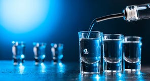 Vodka poured into a glass lit with blue backlight stock images Vodka poured into a glass lit with blue backlight stock images